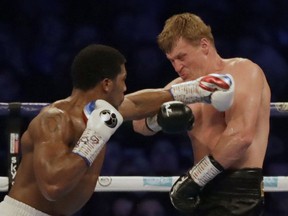 British boxer Anthony Joshua, left, fights Russian boxer Alexander Povetkin in their WBA, IBF, WBO and IBO heavyweight titles fight at Wembley Stadium in London, Saturday, Sept. 22, 2018.