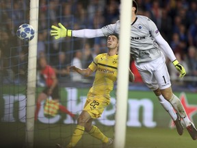Borussia Dortmund's Christian Pulisic, center, scores his side's first goal as Brugge goalkeeper Karlo Letica dives to stop the ball during a Champions League group A soccer match between Club Brugge and Borussia Dortmund at the Jan Breydel Stadium in Bruges, Belgium, Tuesday, Sept. 18, 2018.