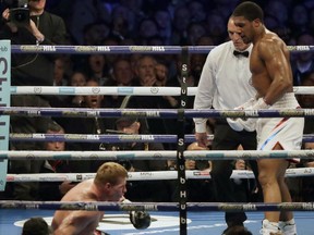 Russian boxer Alexander Povetkin goes down after taking a series of punches from British boxer Anthony Joshua, right, in their WBA, IBF, WBO and IBO heavyweight titles fight at Wembley Stadium in London, Saturday, Sept. 22, 2018. Joshua won in the seventh round on a technical knockout.