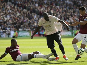 West Ham's Issa Diop, left, and West Ham's Fabian Balbuena, right, challenge Manchester United's Romelu Lukaku, center, during the English Premier League soccer match between West Ham United and Manchester United at London Stadium in London in London, England, Saturday, Sept. 29, 2018.