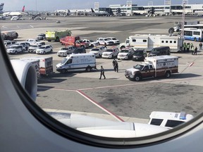 Emergency response crews gather outside a plane at New York's Kennedy Airport amid reports of ill passengers aboard a flight from Dubai on Wednesday, Sept. 5, 2018.