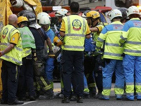 An injured worker is carried on a stretcher after scaffolding collapsed at the Ritz hotel undergoing renovation in Madrid, Spain, Tuesday, Sept. 18, 2018.  One construction worker was killed and at least 11 injured after wrought iron work on the sixth floor of the hotel collapsed dragging down five floors of internal scaffolding and the workers at the site.