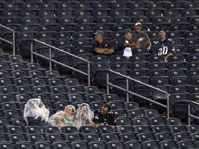 Fans sit in a rain storm as severe weather delays the start of an NFL football game between the Philadelphia Eagles and the Atlanta Falcons, Thursday, Sept. 6, 2018, in Philadelphia.