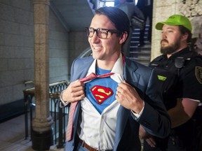 Prime Minister Justin Trudeau shows off his costume as Clark Kent, alter ego of comic book superhero Superman, as he walks through the House of Commons, in Ottawa on Tuesday, October 31, 2017.