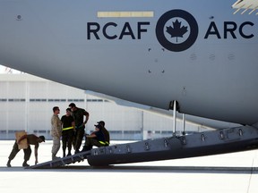 Technicians on the ramp of a CC-177 Globemaster III plane await the arrival of their cargo   Tuesday, July 3, 2018 at Canadian Forces Base Trenton, Ont.The Royal Canadian Air Force is contending with a shortage of around 275 pilots and needs more mechanics, sensor operators and other trained personnel as well in the face of increasing demands to conduct and support domestic and international missions.