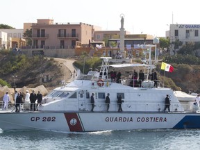 FILE - In this July 8, 2013 file photo, Pope Francis, small white figure seen sitting on top of a Coast Guard boat, arrives in the island of Lampedusa, southern Italy. In a message Saturday, Sept. 1, 2018, Francis urged politicians to apply "farsighted responsibility" and generosity in dealing with migration policies including about those who "risk their lives at sea in search of a better future" and about climate change.