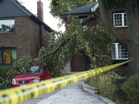 Police tape guards against fallen power lines after a large tree branch fell in a west-end Toronto neighbourhood Friday, Sept. 21, 2018. Environment Canada says a tornado touched down in Ottawa and Gatineau, Que., on Friday afternoon as much of southern Ontario saw severe thunderstorms and high wind gusts.