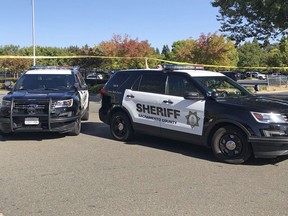 Police vehicles block streets some distance away from there two Sacramento County sheriff's deputies and a bystander were shot during an incident in Rancho Cordova, Calif., just outside Sacramento, Monday, Sept. 17, 2018. Department spokesman Sgt. Shaun Hampton says the suspect is in custody. Hampton says the shooting Monday afternoon occurred at a Pep Boys auto parts store, but did not provide details on the deputies' or the bystander's condition.