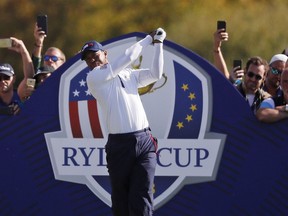 Spectators take photos of Tiger Woods of the US as he tees off from the 6th hole during a foursome match on the second day of the 42nd Ryder Cup at Le Golf National in Saint-Quentin-en-Yvelines, outside Paris, France, Saturday, Sept. 29, 2018.