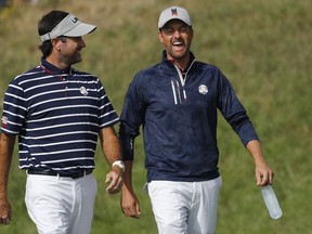 Bubba Watson of the US, left, and his teammate Webb Simpson of the US walk on the fairway during their foursome match on the opening day of the 2018 Ryder Cup at Le Golf National in Saint Quentin-en-Yvelines, outside Paris, France, Friday, Sept. 28, 2018.