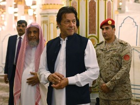 In this Tuesday, Sept. 18, 2018, photo released by the state-run Saudi Press Agency, Pakistani Prime Minister Imran Khan, center, visits the Prophet's Mosque in Medina, Saudi Arabia. Khan, a former cricketer, is on a tour of Saudi Arabia and the United Arab Emirates as part of his first overseas trip since taking office. (Saudi Press Agency via AP)