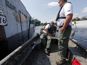 Department of Natural Resources agent James Mills ducks around a street sign as he patrols with fellow agent Cody Britt through floodwaters in the aftermath of Hurricane Florence in Nichols, S.C., Friday, Sept. 21, 2018. Virtually the entire town is flooded and inaccessible except by boat, just two years after it was flooded by Hurricane Matthew.