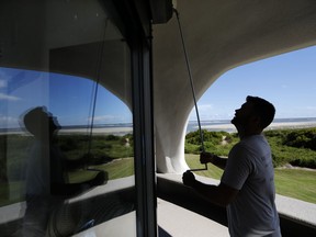 Chris Brace, from Charleston, S.C. lowers hurricane shutters on a client's house in preparation for Hurricane Florence at Sullivan's Island, S.C., Monday, Sept. 10, 2018. Brace said that after S.C. Gov. Henry McMaster ordered an evacuation the property owner asked for the house to be boarded up.