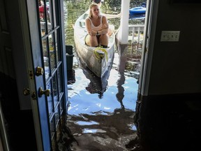 Maura Walbourne sits in the front of a canoe looking in at her flooded Long Avenue home as David Covington wades through the wreckage in Conway, S.C. Sunday, Sept. 23, 2018 The Sherwood Drive area of Conway began to look like a lake on Sunday as homes were submerged deeper than ever in flood waters that have already set historic records.