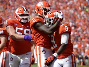 Clemson's Travis Etienne (9) celebrates his touchdown with Tee Higgins (5) and Gage Cervenka during the second half of an NCAA college football game against Syracuse, Saturday, Sept. 29, 2018, in Clemson, S.C. Clemson won 27-23.