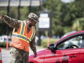 A National Guardsman directs traffic onto U.S. Highway 501 as Hurricane Florence approaches the East Coast Wednesday, Sept. 12, 2018, near Conway, S.C. Time is running short to get out of the way of Hurricane Florence, a monster of a storm that has a region of more than 10 million people in its potentially devastating sights.