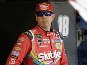 Kyle Busch stands near his car in the garage before a NASCAR Cup Series auto racing practice session at Darlington Raceway, Friday, Aug. 31, 2018, in Darlington, S.C.