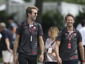 Haas Driver Romain Grosjean of France, right, arrives at the Marina Bay City Circuit ahead of the Singapore Formula One Grand Prix in Singapore, Friday, Sept. 14, 2018.