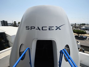 n this file photo taken on August 13, 2018 a mock up of the Crew Dragon spacecraft is displayed during a media tour of SpaceX headquarters and rocket factory in Hawthorne, California. - SpaceX on Thursday, September 13, 2018, announced a new plan to send a tourist around the Moon on its Big Falcon Rocket (BFR), a massive launch vehicle that is being designed to carry people to deep space.