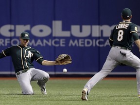 Oakland Athletics right fielder Stephen Piscotty and second baseman Jed Lowrie (8) can't get to a single by Tampa Bay Rays' Mallex Smith during the first inning of a baseball game Friday, Sept. 14, 2018, in St. Petersburg, Fla.