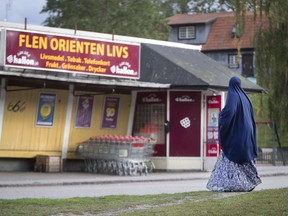 In this Aug. 30, 2018 photo a migrant woman stands in front of an orient supermarket in Flen, some 100 km west of Stockholm, Sweden. The town has welcomed so many asylum seekers in recent years that they now make up about a fourth of the population.