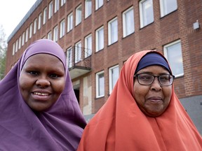 In this Aug. 30, 2018 photo Marian Omar, left, and Anab Adan, both from Somalia, pose in front of the town hall in Flen, some 100 km west of Stockholm, Sweden. The town has welcomed so many asylum seekers in recent years that they now make up about a fourth of the population.
