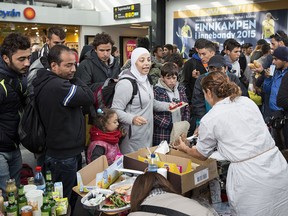 Volunteers distribute food and drink to refugees arriving at the train station in Malmoe, Sweden, in a file photo from Sept. 10, 2015.