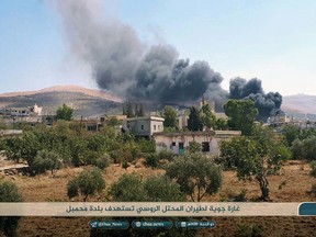 This photo released Tuesday, Sept 4, 2018 by the al-Qaida-affiliated Ibaa News Agency, shows smoke rising over buildings that were hit by airstrikes, in Mahambal village, in the northern province of Idlib, Syria.