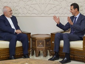 This picture released by the official Syrian Arab News Agency (SANA) shows Iran's Foreign Minister Mohammad Javad Zarif (L) meeting with Syrian President Bashar al-Assad (R) in Damascus on September 3, 2018.