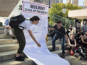 A giant Charter of Rights is rolled out for people to sign during the Save our Democracy and Rights event outside City Hall in Toronto on Wednesday, September 12, 2018.
