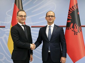 Albanian Foreign Minister Ditmir Bushati, right, welcomes, his German counterpart Heiko Maas during their meeting in Tirana, Wednesday, Sept. 19, 2018.