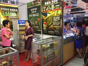 Staff at a booth selling North Korean honey and other goods wait for customers at the 14th Pyongyang Autumn International Trade Fair in Pyongyang, North Korea on Monday, Sept. 17, 2018. Despite continuing sanctions and political uncertainties, this year the fair is making something of a comeback, with more than 320 companies and a large Chinese continent participating. North Korea is hoping its recent diplomatic outreach to its neighbors and its talks with Washington will help break down support for sanctions and open the way for it to boost its trade with the outside world.