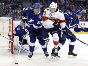 Tampa Bay Lightning defenseman Mikhail Sergachev (98) controls the puck in front of Florida Panthers right wing Evgenii Dadonov (63) during the first period of an NHL preseason hockey game Tuesday, Sept. 25, 2018, in Tampa, Fla. Defending for the Lightning is Alex Killorn (17).