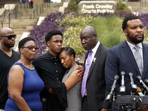 Brandt Jean, center left, brother of shooting victim Botham Jean, hugs his sister Allisa Charles-Findley, during a news conference outside the Frank Crowley Courts Building on Monday, Sept. 10, 2018, in Dallas, about the shooting of Botham Jean by Dallas police officer Amber Guyger on Thursday. He was joined by his mother, Allison Jean, second from left, and attorney Benjamin Crump, second from right, as attorney Lee Merritt, right, speaks to the media.