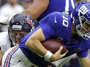 Houston Texans defensive end J.J. Watt, left, sacks New York Giants quarterback Eli Manning (10) during the second half of an NFL football game Sunday, Sept. 23, 2018, in Houston.