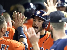 Houston Astros' George Springer celebrates in the dugout after hitting a three-run home run against the Los Angeles Angels during the eighth inning of a baseball game Friday, Sept. 21, 2018, in Houston.