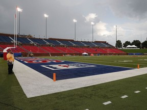 A security guard stands on the field during an inclement weather delay before an NCAA college football game between TCU and SMU, Friday, Sept. 7, 2018, in Dallas.
