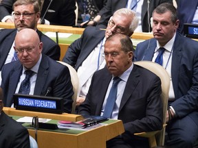 Russian Foreign Minister Sergey Lavrov, right, and Ambassador to the United Nations Vassily Nebenzia, center, listen as American President Donald Trump addresses the 73rd session of the United Nations General Assembly, Tuesday, Sept. 25, 2018 at U.N. headquarters.