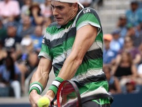 John Isner returns a shot to Milos Raonic, of Canada, during the fourth round of the U.S. Open tennis tournament, Sunday, Sept. 2, 2018, in New York.