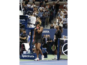 Naomi Osaka, of Japan, reacts as Serena Williams talks with chair umpire Carlos Ramos after Osaka defeated Williams in the women's final of the U.S. Open tennis tournament, Saturday, Sept. 8, 2018, in New York.