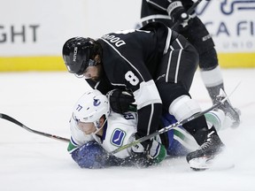 Vancouver Canucks forward Nikolay Goldobin (77) and Los Angeles Kings defenseman Drew Doughty (8) battle in the second period in a preseason NhL hockey game Monday, Sept., 24, 2018, in Salt Lake City.