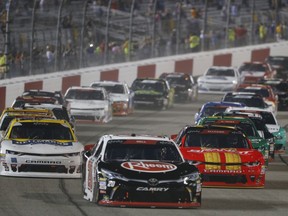 Christopher Bell (20) leads the pack at the start of the NASCAR Xfinity Series auto race at Richmond Raceway in Richmond, Va., Friday, Sept. 21, 2018.