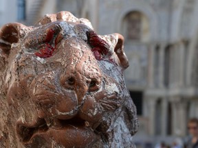 A stone lion next to St. Mark's Basilica, its eyes stained with red paint, is seen in Venice, Italy, Saturday, Sept. 29, 2018. One of the two stone lions that stand guard next to Venice's famed St. Mark's Basilica has been vandalized with red paint. Residents raised the alarm early Saturday after noticing the paint splashed on the eyes and mane of the red marble "leoncino" statue, located on a small piazza next to the basilica.