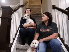 In this photo taken Monday, Sept. 24, 2018, Las Vegas shooting survivor Chris Gilman, right, sits with her wife Aliza Correa and their two dogs at their home in Bonney Lake, Wash. Gilman, with her wife at her side, was shot at the Route 91 country music festival on the Las Vegas Strip a year earlier. Today Gilman and Correa are making a conscious effort to keep at bay what they experienced and witnessed from spoiling their everyday moments home, an hour southeast of Seattle.