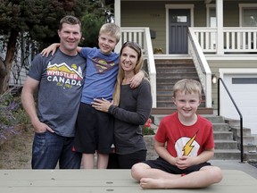 In this photo taken Sept. 10, 2018, Tricia and Steve Schalekamp pose for a photo with their sons Alex, 6, right, and Evan, 9, at their home in Seattle. The family paid at least $500 in non-refundable waiting list fees for preschool for Evan, now a third grader, and never even got a call back from those places. The money-back-not-guaranteed caveat to an already grueling, emotional search for daycare services is now becoming routine in booming U.S. cities, where demand for high-quality preschools is high and supply is starkly limited.