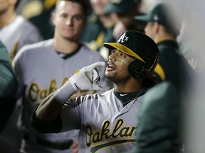 Oakland Athletics' Khris Davis celebrates in the dugout after hitting a solo home run on a pitch from Seattle Mariners' Adam Warren during the sixth inning of a baseball game, Monday, Sept. 24, 2018, in Seattle.