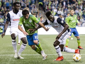 Seattle Sounders midfielder Nicolas Lodeiro (10) loses the ball to Philadelphia Union forward C.J. Sapong on the edge of the box  during the first half of an MLS soccer match Wednesday, Sept. 19, 2018, in Seattle.