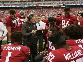 Washington State head coach Mike Leach center, speaks with his team during the first half of an NCAA college football game against Eastern Washington in Pullman, Wash., Saturday, Sept. 15, 2018.