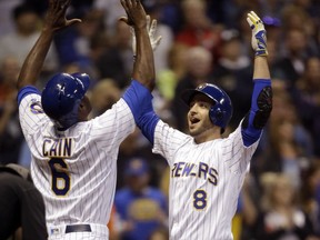 Milwaukee Brewers' Ryan Braun, right, reacts with Lorenzo Cain after hitting a two-run home run against the San Francisco Giants during the first inning of a baseball game Friday, Sept. 7, 2018, in Milwaukee.