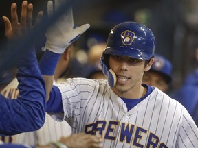 Milwaukee Brewers' Christian Yelich is congratulated after hitting a two-run home run during the first inning of a baseball game against the Detroit Tigers Friday, Sept. 28, 2018, in Milwaukee.